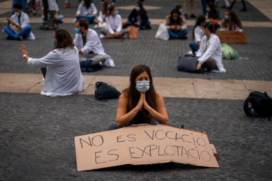 Medical residents take part on a protest against their working conditions during a strike in Barcelona, Spain, Thursday, Oct. 22, 2020. Spain has reported 1 million confirmed infections the highest number in Western Europe and at least 34,000 deaths from COVID-19, although experts say the number is much higher since many cases were missed because of testing shortages and other problems. Banner reads in Spanish: Medical residents take part on a protest against their working conditions during a strike in Barcelona, Spain, Thursday, Oct. 22, 2020. Spain has reported 1 million confirmed infections the highest number in Western Europe and at least 34,000 deaths from COVID-19, although experts say the number is much higher since many cases were missed because of testing shortages and other problems. Banner reads in Spanish: