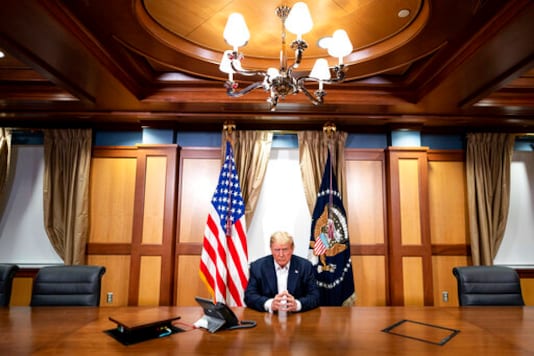 In this image provided by the White House, President Donald Trump listens during a phone call with Vice President Mike Pence, Secretary of State Mike Pompeo, and Chairman of the Joint Chiefs of Staff Gen. Mark Milley, Sunday, Oct. 4, 2020, in his conference room at Walter Reed National Military Medical Center in Bethesda, Md. White House chief of staff Mark Meadows was also in the room, but not pictured, according to the White House. (Tia Dufour/The White House via AP) In this image provided by the White House, President Donald Trump listens during a phone call with Vice President Mike Pence, Secretary of State Mike Pompeo, and Chairman of the Joint Chiefs of Staff Gen. Mark Milley, Sunday, Oct. 4, 2020, in his conference room at Walter Reed National Military Medical Center in Bethesda, Md. White House chief of staff Mark Meadows was also in the room, but not pictured, according to the White House. (Tia Dufour/The White House via AP)