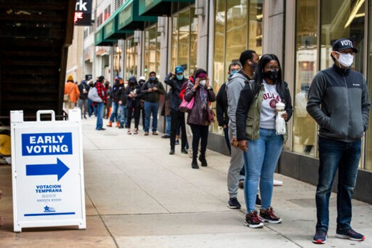 FILE - In this Oct. 1, 2020, file photo, hundreds of people wait in line to early vote in Chicago. Black Americans and other people of color say President Donald Trumps refusal to outright condemn white nationalists during this weeks debate has strengthened their resolve to vote.(Ashlee Rezin Garcia/Chicago Sun-Times via AP, File) FILE - In this Oct. 1, 2020, file photo, hundreds of people wait in line to early vote in Chicago. Black Americans and other people of color say President Donald Trumps refusal to outright condemn white nationalists during this weeks debate has strengthened their resolve to vote.(Ashlee Rezin Garcia/Chicago Sun-Times via AP, File)
