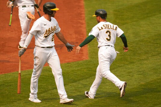 Oakland Athletics' Tommy La Stella (3) is congratulated by Matt Olson after scoring against the Chicago White Sox during the fourth inning of Game 3 of an American League wild-card baseball series Thursday, Oct. 1, 2020, in Oakland, Calif. (AP Photo/Eric Risberg)