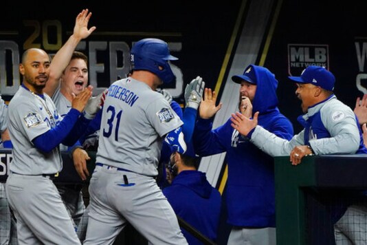 Los Angeles Dodgers' Joc Pederson celebrates in the dugout after his two RBI-single against the Tampa Bay Rays during the seventh inning in Game 4 of the baseball World Series Saturday, Oct. 24, 2020, in Arlington, Texas. (AP Photo/Tony Gutierrez)