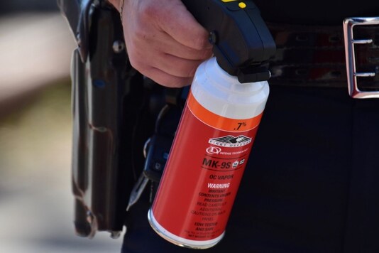 A police officer carries a bottle of pepper spray near a Get Out The Vote march in Graham, North Carolina, U.S. October 31, 2020. Anthony Crider/Handout via REUTERS A police officer carries a bottle of pepper spray near a Get Out The Vote march in Graham, North Carolina, U.S. October 31, 2020. Anthony Crider/Handout via REUTERS