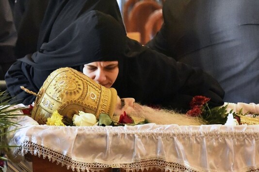 A nun kisses the Bishop Amfilohije's body during the liturgy and funeral in the main temple in the capital Podgorica, Montenegro, Sunday, Nov. 1, 2020. Bishop Amfilohije died on Friday after contracting the coronavirus weeks ago. A mass funeral on Sunday was held for the popular head of the Serbian Orthodox Church in Montenegro in violation of restrictions that are in place against the new coronavirus. (AP Photo/Risto Bozovic)
