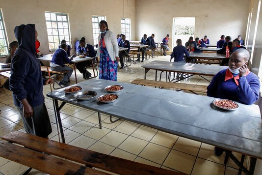 Visually impaired pupils practice social distancing while the headteacher Margaret Njuguna guides them during lunch at the Thika school for the blind in Thika town of Kiambu county, Kenya. (REUTERS/Monicah Mwangi)
