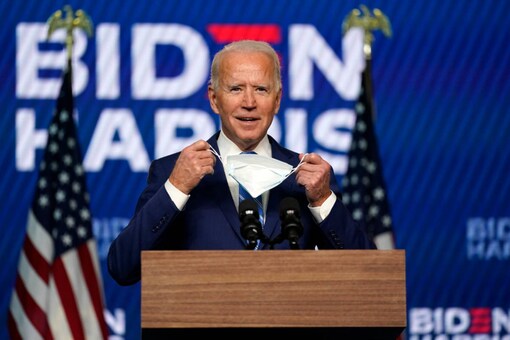 Democratic presidential candidate former Vice President Joe Biden puts his face mask on after speaking Wednesday, Nov. 4, 2020, in Wilmington, Del. (AP Photo/Carolyn Kaster)