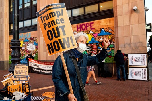 A protester stages demonstration against President Donald Trump outside Twitter headquarters on Thursday, Nov. 5, 2020, in San Francisco. About a dozen demonstrators with Refuse Fascism, which has been protesting Trump since shortly before his inauguration, took part. (AP Photo/Noah Berger)