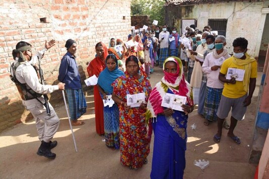 Voters display their identity cards outside a polling station at Paliganj, in Bihar. (AP Photo/Aftab Alam Siddiqui)
