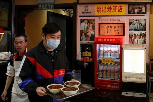 A man carries his foods past photos of Joe Biden on display at a restaurant where he visited in 2011 as U.S. vice president, in Beijing. (AP Photo/Andy Wong) A man carries his foods past photos of Joe Biden on display at a restaurant where he visited in 2011 as U.S. vice president, in Beijing. (AP Photo/Andy Wong)