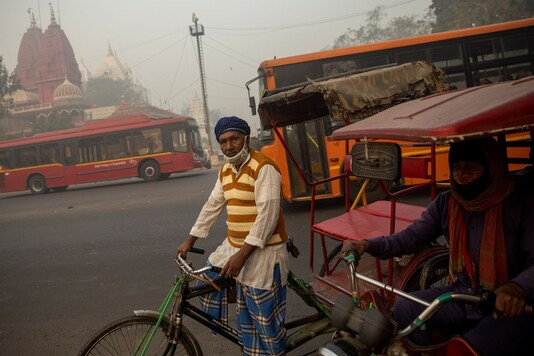 A rickshaw puller waits for customers on a smoggy morning in the old quarters of Delhi. (Reuters)