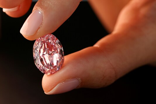  A model poses with 'The Spirit of the Rose', the world's largest vivid purple-pink diamond with 14.83-carat, before an upcoming Geneva auction on November 11 where it could fetch up to $38 million, during a Sotheby's preview in Geneva, Switzerland, November 6, 2020. REUTERS/Denis Balibouse/File Photo