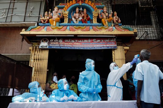 Healthcare workers wearing personal protective equipment (PPE) test a resident at a camp set up outside a temple in Dharavi, one of Asia's largest slums, Mumbai, on June 7, 2020. (REUTERS/Francis Mascarenhas)