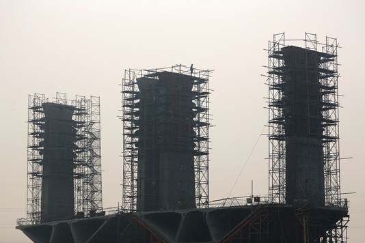 A worker works at an overpass construction site amid smog in New Delhi.  (Reuters)