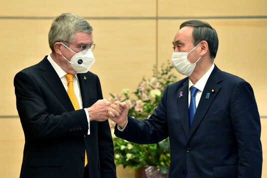 Thomas Bach (L) and Yoshihide Suga (Photo Credit: AP)