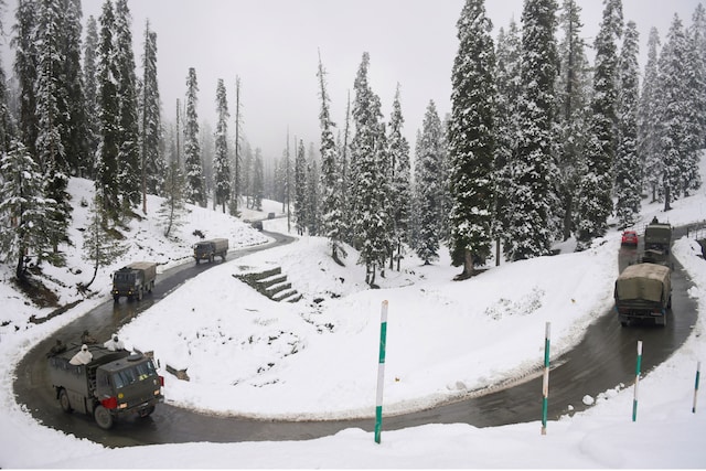 An army convoy moves on a snow covered road after the season's first snowfall, at Gulmarg in Baramulla district of north Kashmir, Monday, Nov. 16, 2020. (PTI Photo/S. Irfan)
