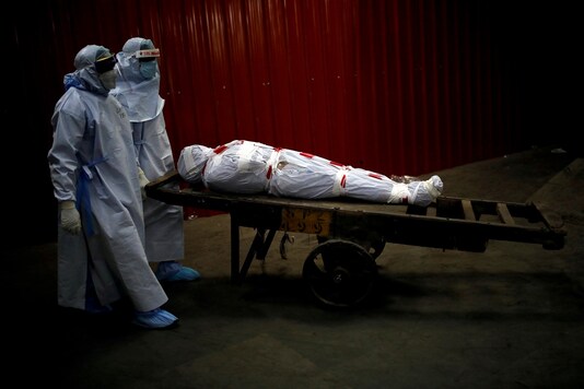 Health workers carry the body of a man who died due to the coronavirus disease (COVID-19) for his cremation at a crematorium in New Delhi. (Reuters)