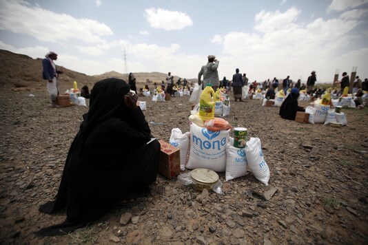 A woman sits next to food aid she received from the local charity, Mona Relief, ahead of the holy month of Ramadan on the outskirts of Sanaa. (File photo/REUTERS)