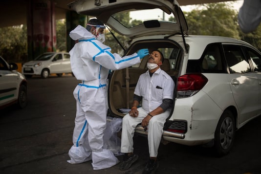 A health worker takes a nasal swab sample of a man to test for COVID-19 during random testing of people at the Delhi-Noida border on the outskirts of New Delhi. (AP)
