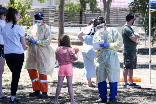 Medical personnel speak to people at a station at Parafield Airport in Adelaide during the first day of the statewide total lockdown to combat the Covid-19 coronavirus on November 18, 2020 (Photo by Brenton EDWARDS / AFP).