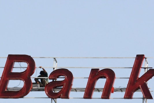 एक मजदूर पश्चिमी भारतीय शहर अहमदाबाद में एक बैंक भवन के चिन्ह पर काम करता है।  (REUTERS / अमित दवे / फाइल फोटो)