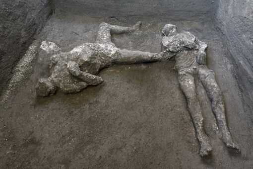 The casts of what are believed to have been a rich man and his male slave fleeing the volcanic eruption of Vesuvius nearly 2,000 years ago, are seen in what was an elegant villa on the outskirts of the ancient Roman city of Pompeii destroyed by the eruption in 79 A.D., where they were discovered during recents excavations, Pompeii archaeological park officials said Saturday, Nov. 21, 2020. (Parco Archeologico di Pompei via AP)
