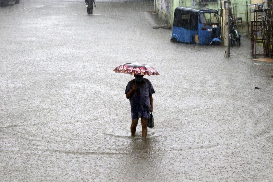  A man wades through a flooded street in Chennai. (Image: AP)