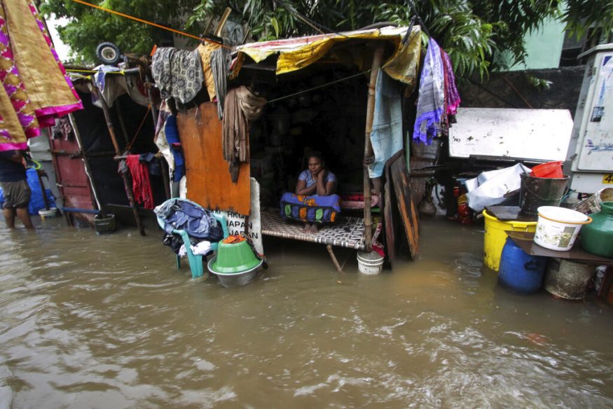  A woman sits inside her hut at a flooded street in Chennai. (Image: AP)