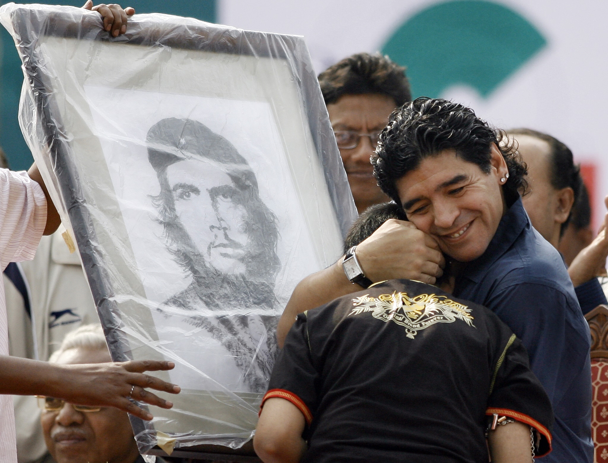  Argentina's national football team coach and former football star Diego Armando Maradona (R) greets the young artist who painted and presented him with a portrait of revolutionary Che Guevara during the laying of the foundation stone for the Indian Football School at Maheshtala, on the outskirts of Kolkata on December 6, 2008. Maradona laid the foundation stone of the Indian Football School (IFS) on the first day of his two-day visit to the city of Kolkata. AFP PHOTO/Deshakalyan CHOWDHURY (Photo: AFP)