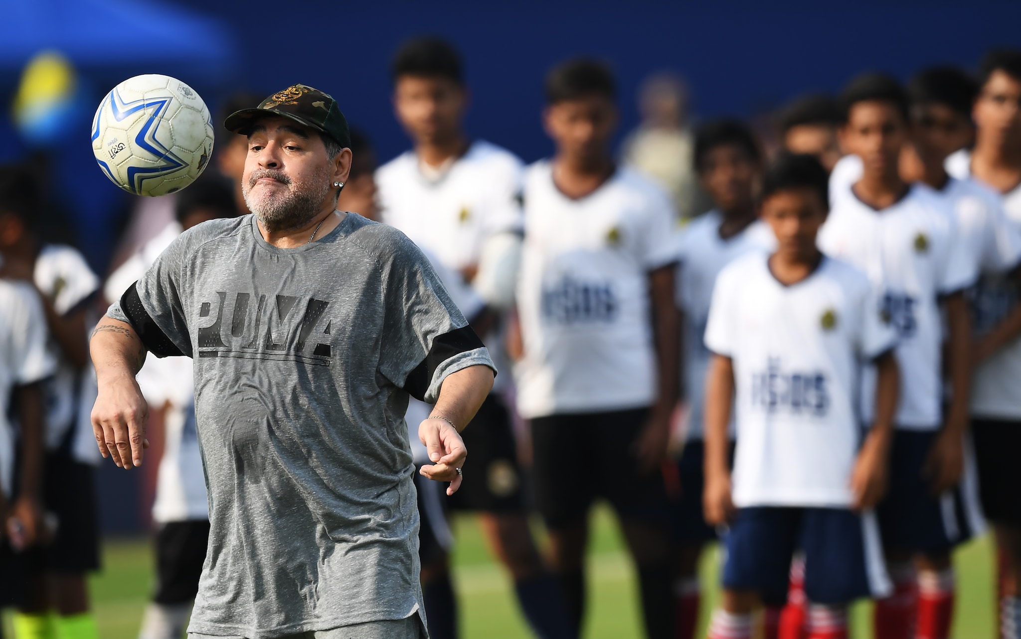  Argentine footballer Diego Maradona (L) plays the ball during a football workshop with school students in Barasat, around 35 Km north of Kolkata on December 12, 2017. - Maradona is on a private visit to India. (Photo: AFP)