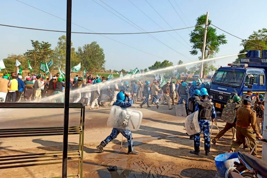 Police deploy water cannons during a clash with various members of farmer organisations, as they marched towards Delhi protesting against the farm reform bills, in Hisar district, Thursday. (PTI Photo)