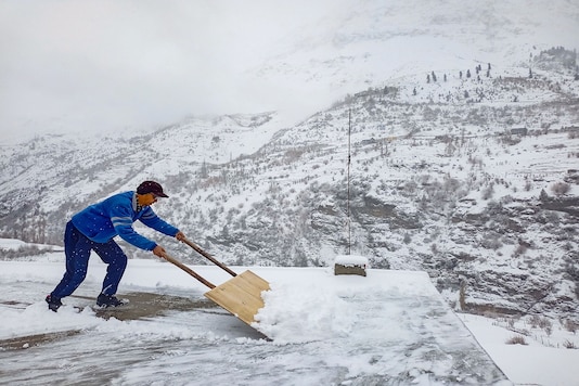 A man clears snow from a roof after fresh snowfall, in Lahaul-Spiti. (PTI) A man clears snow from a roof after fresh snowfall, in Lahaul-Spiti. (PTI)