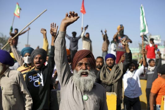 Protesting farmers shout slogans as they clash with policemen while attempting to move towards Delhi, at the border between Delhi and Haryana state on Nov 27. (AP Photo)