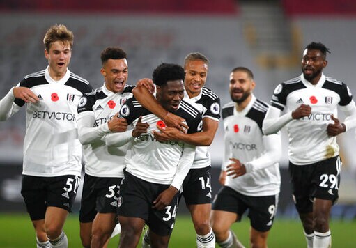 Fulham's Ola Aina, centre, celebrates after scoring his side's second goal during the English Premier League soccer match between Fulham and West Bromwich Albion at Craven Cottage in London, England, Monday, Nov. 2, 2020. (AP Photo/Frank Augstein, Pool)