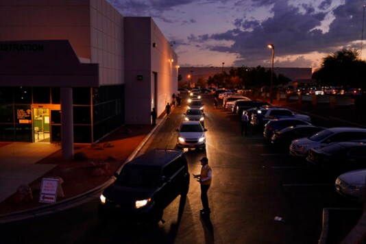 People wait in line in their cars to drop off mail-in ballots in a drive-thru mail-in ballot drop off area at the Clark County Election Department Monday, Nov. 2, 2020, in Las Vegas. (AP Photo/John Locher)