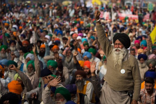 An elderly farmer shouts slogans as others listen to a speaker during a protest at the Delhi-Haryana border, on December 2, 2020. (AP Photo/Altaf Qadri)