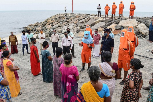 National Disaster Response Force personnel raise awareness among the residents living near Karur Ayyankovikal coast ahead of the landfall of Cyclone Burevi, in Alappuzha district on December 3, 2020. (PTI Photo)