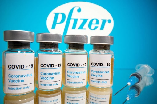 Vials with a sticker reading, 'COVID-19 / Coronavirus vaccine / Injection only' and a medical syringe are seen in front of a displayed Pfizer logo in this illustration taken October 31, 2020. (Image: Reuters)