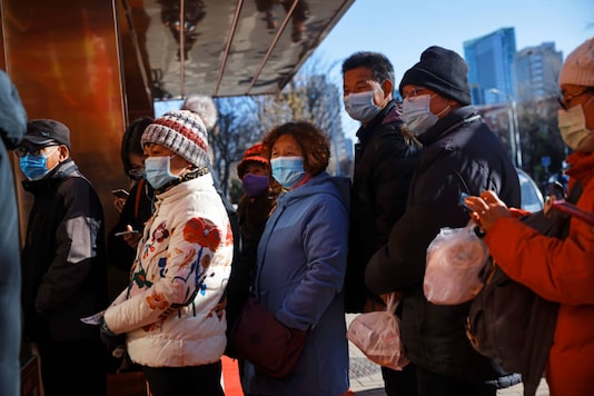 People line up to buy takeaway food, following the outbreak of the coronavirus disease (COVID-19), in Beijing, China on December 4, 2020. (REUTERS/Thomas Peter)