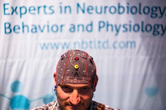 FILE PHOTO: A man demonstrates how he uses a keyboard without typing by wearing a skull-cap with sensors, at a conference on brain technology. (Photo for representation/REUTERS)
