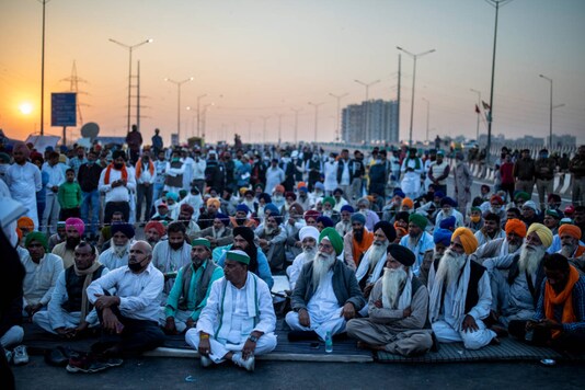 Farmers listen to a speaker in the middle of an expressway at the site of a protest against new farm laws at the Delhi-Uttar Pradesh border, on December 9, 2020. (AP Photo/Altaf Qadri)