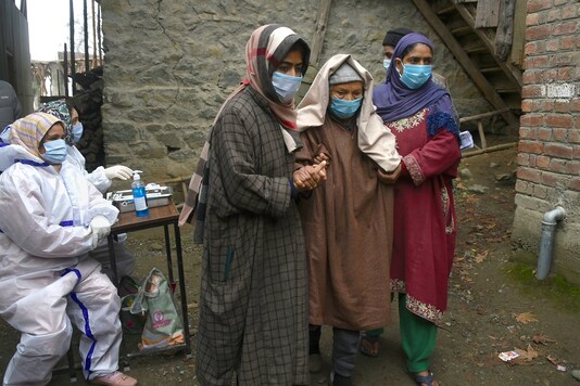 File photo of an elderly voter being escorted by her daughters as she arrives to cast her vote in Kashmir.