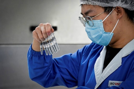 A staff member checking vaccines during a media tour of a new factory built to produce a Covid-19 vaccine at Sinovac, one of 11 Chinese companies approved to carry out clinical trials of potential coronavirus vaccines, in Beijing. (Photo by WANG Zhao / AFP)