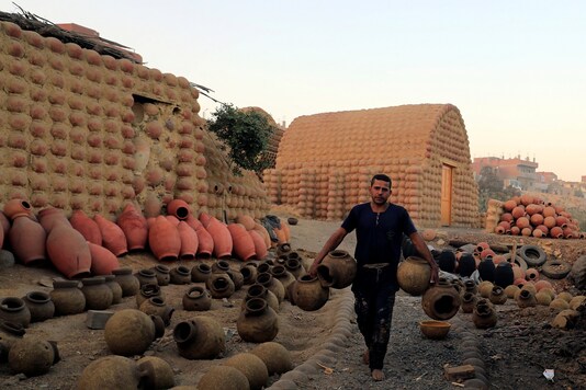 Gaber Ahmed, an Egyptian potter, carries river-clay with traditional shapes of pottery at El Nazla village in Fayoum, southwest of Cairo. REUTERS/Amr Abdallah Dalsh