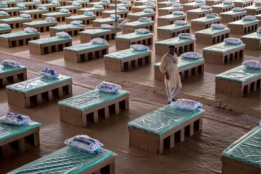 A volunteer walks past disposable beds made out of cardboard at the campus of Radha Soami Satsang Beas, a spiritual organization, where a coronavirus disease (COVID-19) care centre has been constructed for the patients amidst the spread of the disease, in New Delhi, India, June 26, 2020. REUTERS/Danish Siddiqui