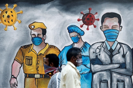 Men walk past a mural of frontline workers amid the spread of the coronavirus disease (COVID-19), in Mumbai on December 21, 2020. (REUTERS)