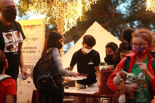 A line of glampers wait to check in and have their temperature taken at the indoor glamping grounds of Changi Airport, Singapore.  REUTERS/Ying Shan Lee