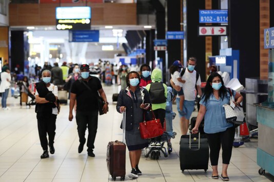 Passengers wearing protective masks walk to the check-in counters at the OR Tambo International Airport in Johannesburg, South Africa. (REUTERS/Siphiwe Sibeko/File photo)
