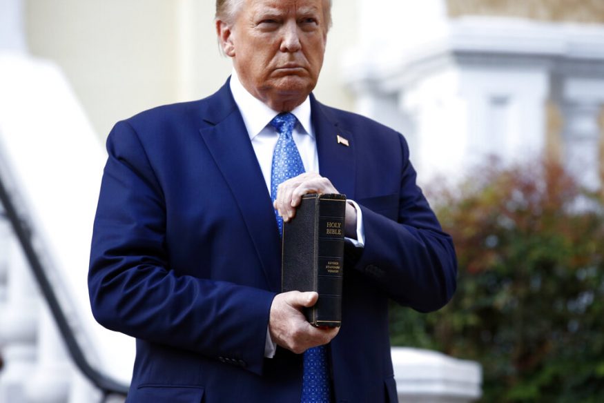  President Donald Trump holds a Bible as he stands outside St. John's Church across Lafayette Park from the White House in Washington after law enforcement officers used tear gas and other riot control tactics to forcefully clear peaceful protesters from the area. (Image: AP)