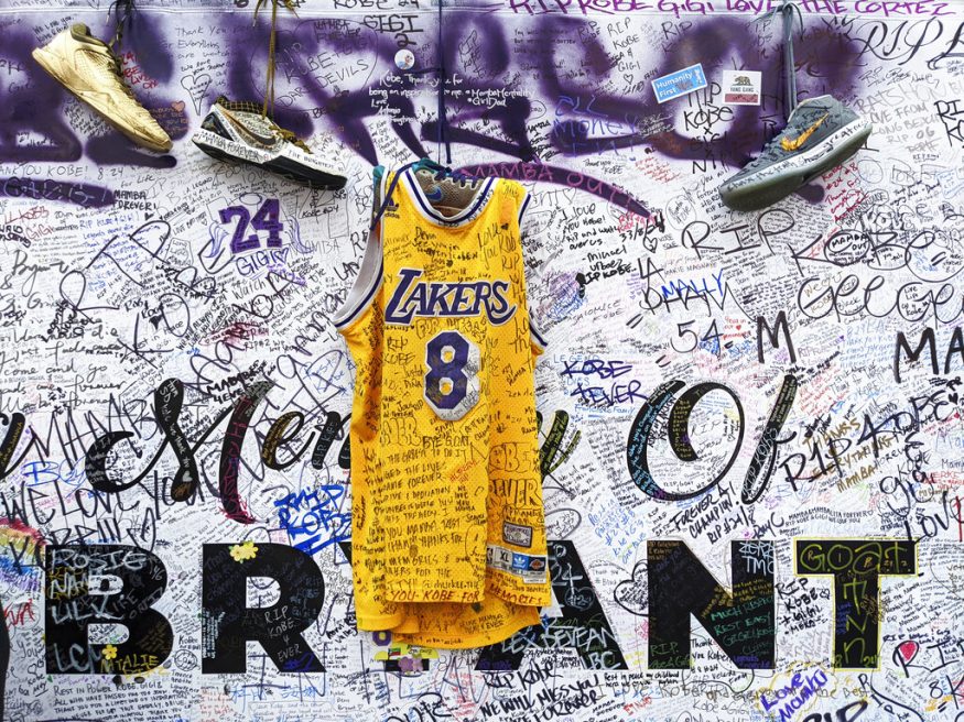  Sneakers and a Los Angeles Lakers jersey with the number 8 worn by NBA star Kobe Bryant hang at a memorial for Bryant in Los Angeles, a week after he was killed in a helicopter crash. (Image: AP)