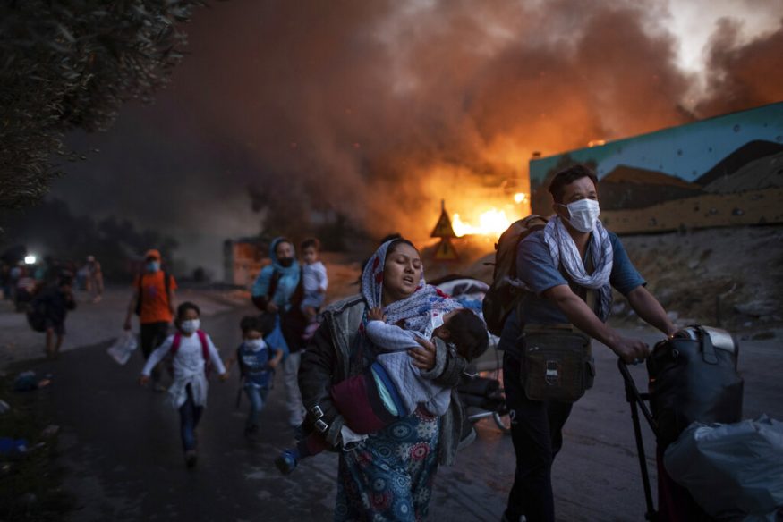  Here's a look at the photographs captured by Associated Press photographers in 2020, a world beset by every sort of catastrophe -- natural and unnatural disaster, violent and non-violent conflict. And, in every corner of that world, the coronavirus.<br /><br />Migrants flee from the second fire in two days at the overcrowded Moria refugee camp on the island of Lesbos, Greece. (Image: AP)