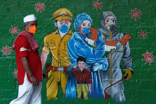A man wearing a protective mask walks past a mural of frontline workers amidst the spread of the coronavirus disease (COVID-19), in Mumbai, India, December 21, 2020. REUTERS/Francis Mascarenhas